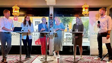 Seks personer diskuterer i panel